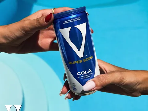 Zwei Freunde stoßen mit V Super Soda Dosen an — besser geteilt