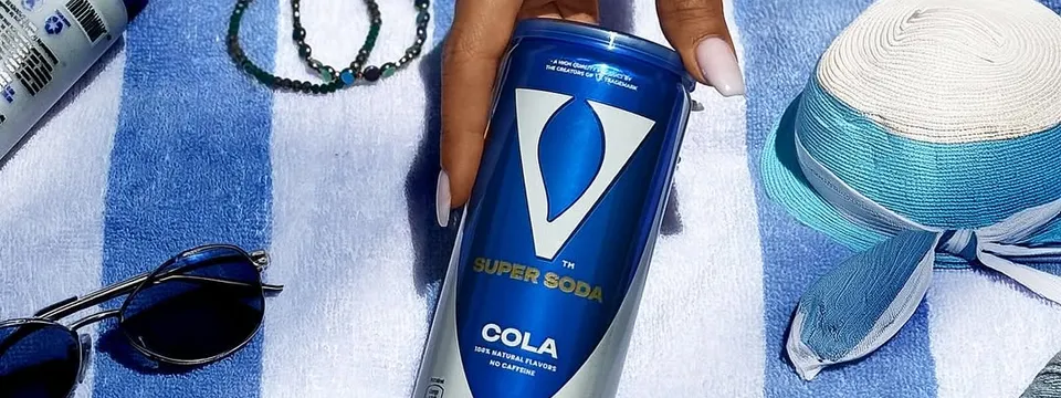 Strand-Szene mit V Super Soda Dose in der Hand — der perfekte Begleiter für sonnige Tage